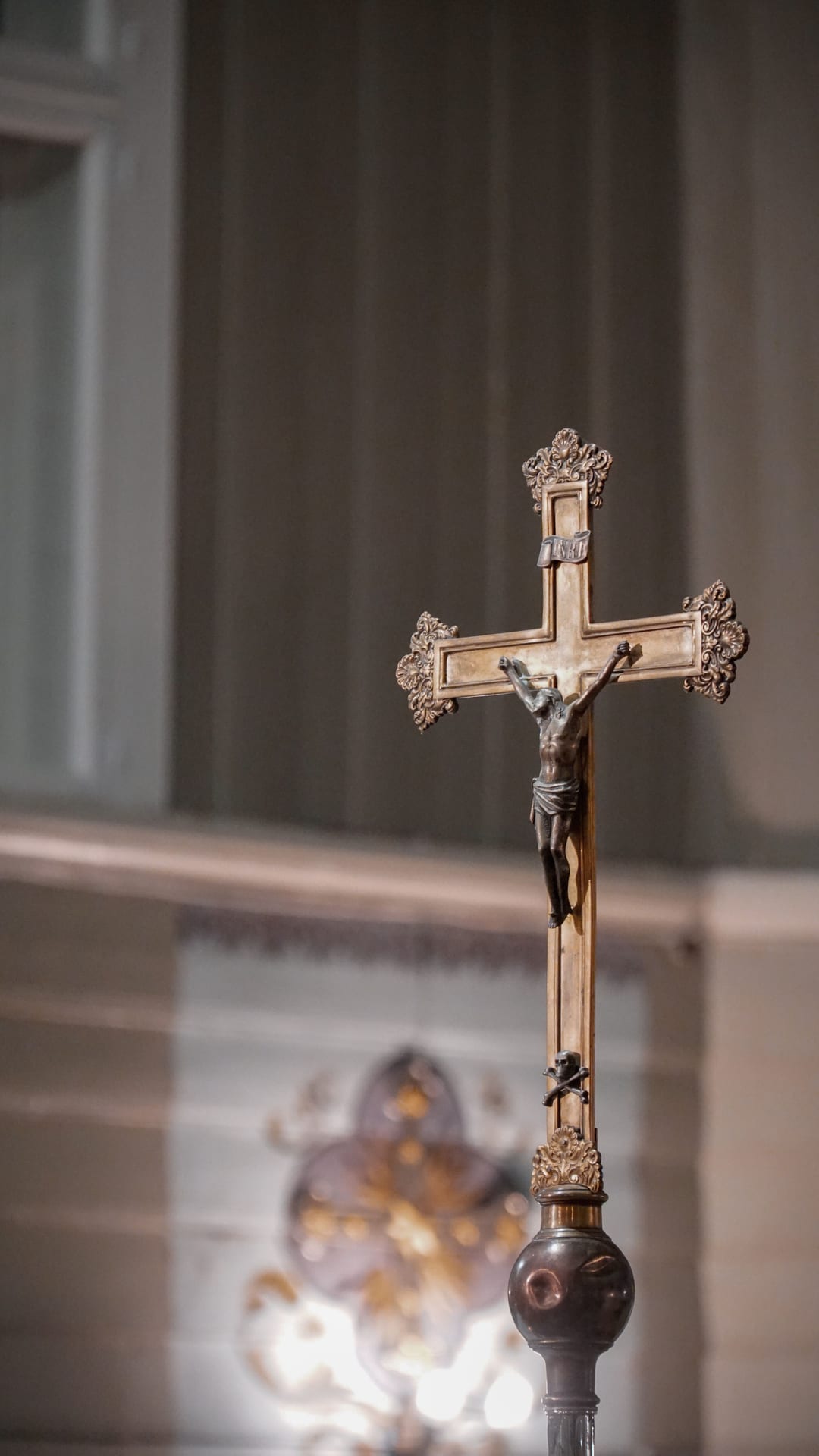 A detailed view of an ornate crucifix within a church interior, symbolizing Christian faith.