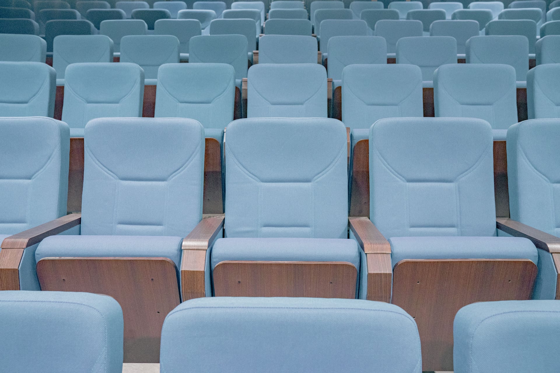 Rows of modern blue theater seats in an empty auditorium, highlighting architectural design.