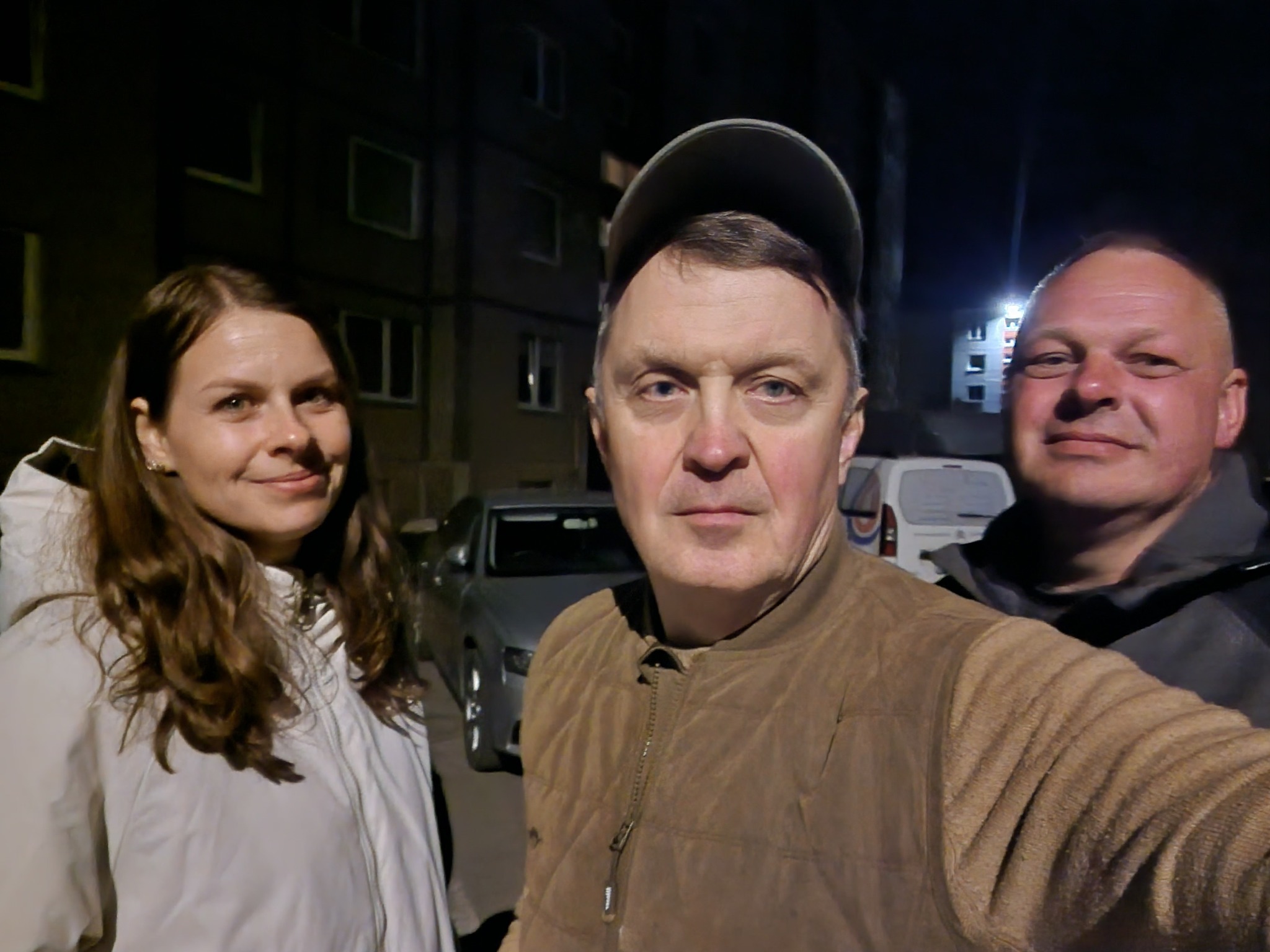 Šiaulių apuoka naktinis reids tarp stogų, medžių ir gaisrines šviesų