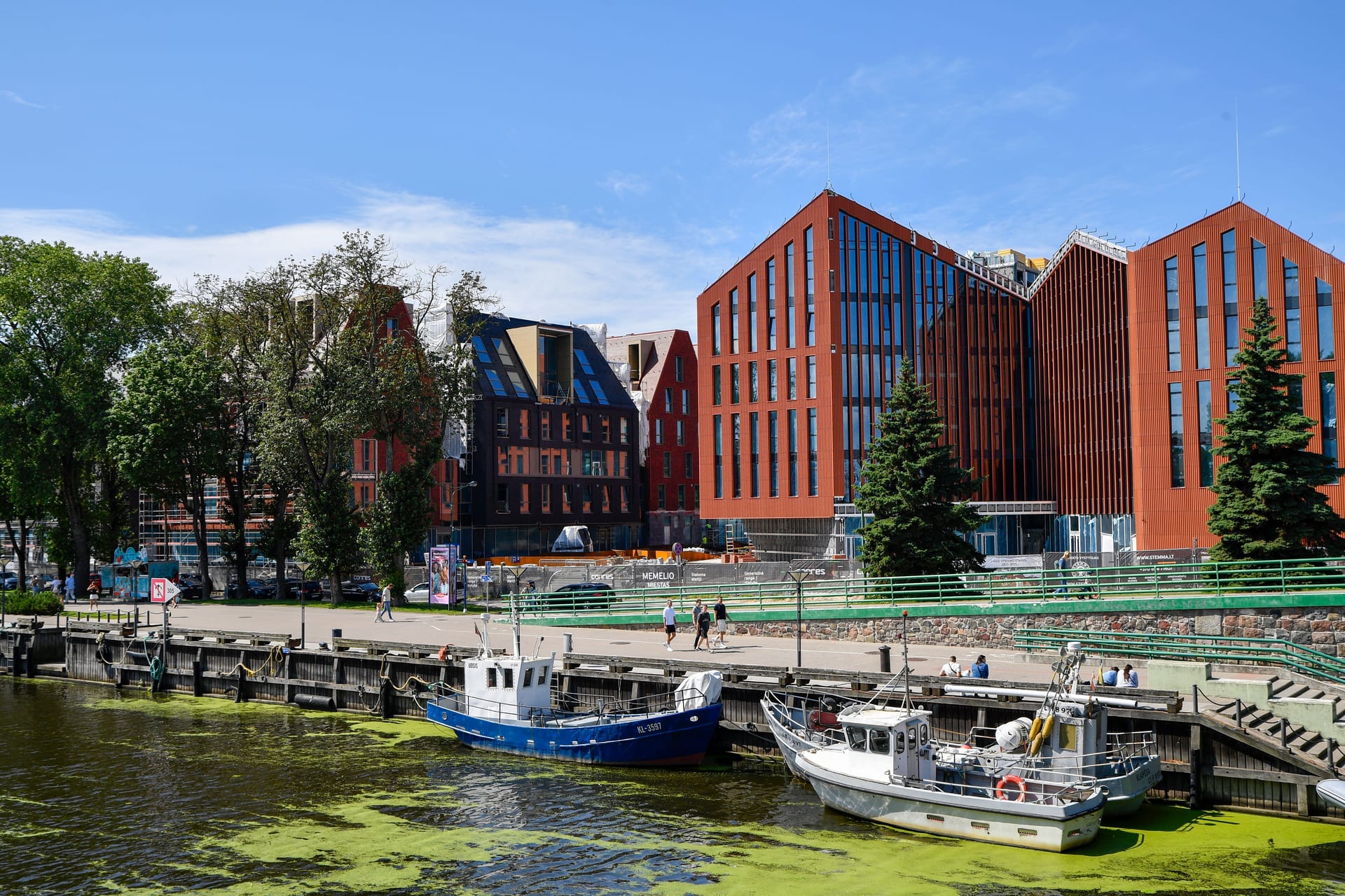 Dynamic waterfront scene in Klaipėda, Lithuania, showcasing modern architecture and vibrant city life.