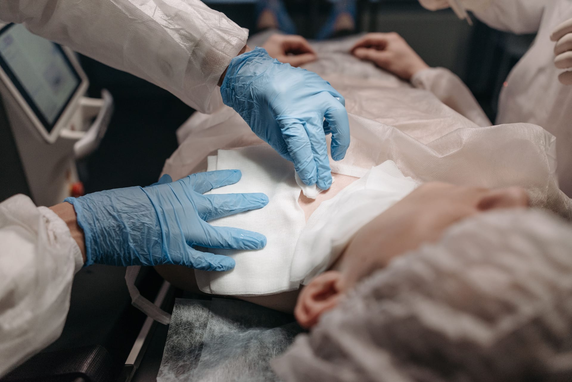 Doctors perform a medical procedure in a sterile environment, focusing on precision and care.